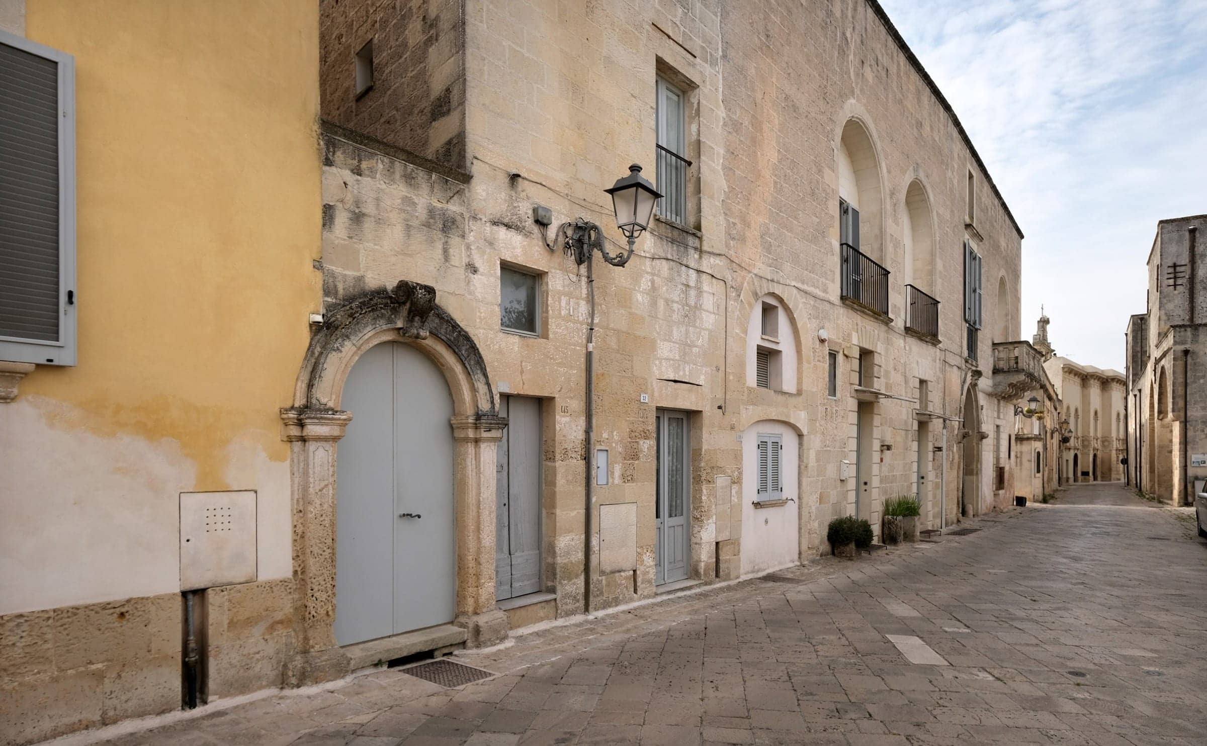 The stone facade of a palazzo on a quiet street in Muro Leccese, Salento