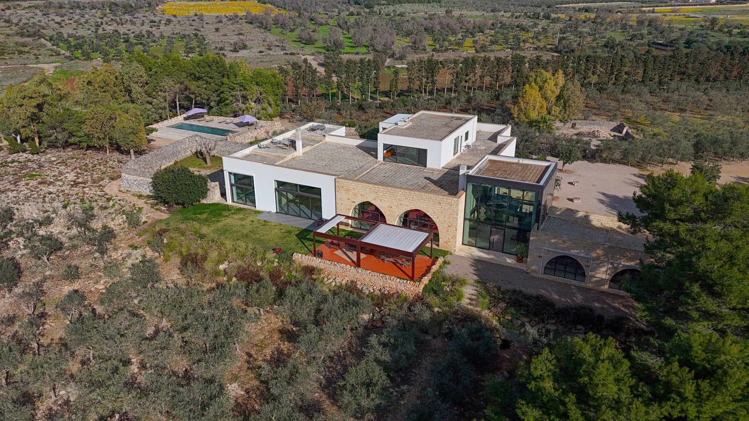 A masseria seen from above, its white volumes set among olive groves in Salento